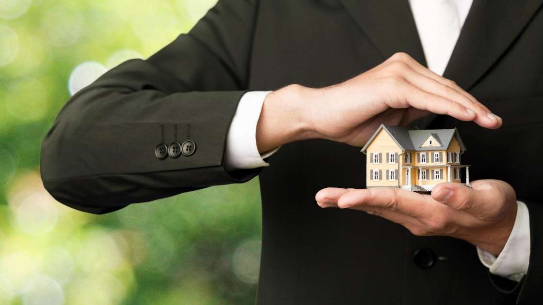 real estate agent holding model of a home
